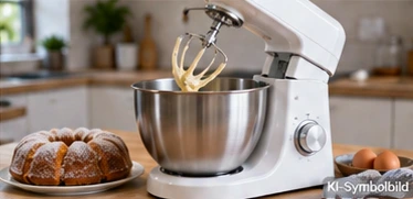 KI-Symbolbild: weiße Rührmaschine mit Edelstahlschüssel neben Kuchen und Eiern