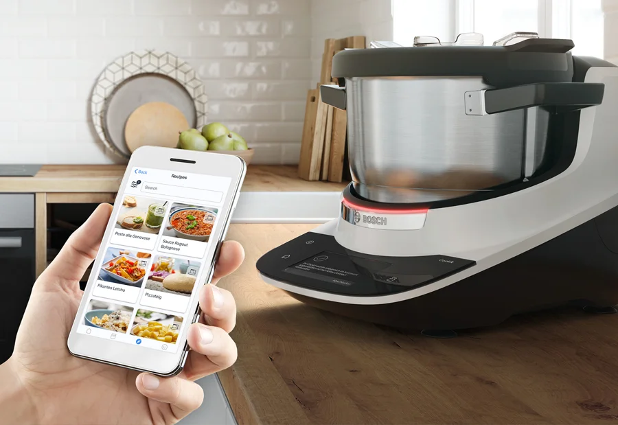 Bosch Cookit in weißer Ausführung mit Home-Connect-Rezeptansicht auf einem Smartphone
